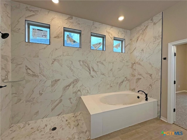 bathroom with separate shower and tub and tile walls