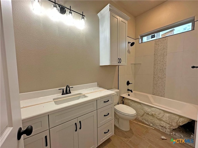 full bathroom featuring tiled shower / bath combo, vanity, and toilet