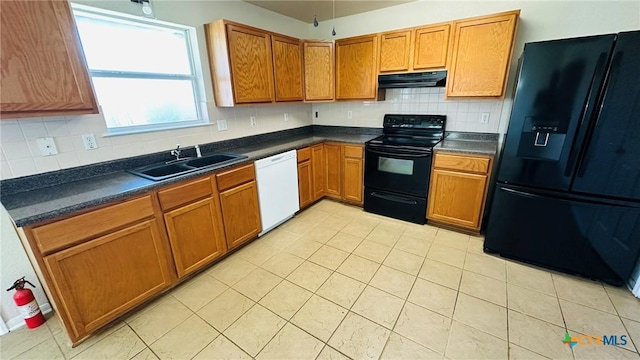 kitchen with brown cabinets, dark countertops, a sink, black appliances, and exhaust hood