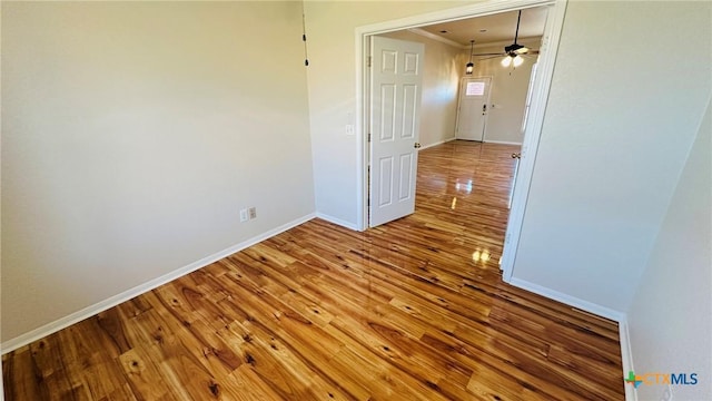 empty room featuring baseboards, a ceiling fan, wood finished floors, and ornamental molding