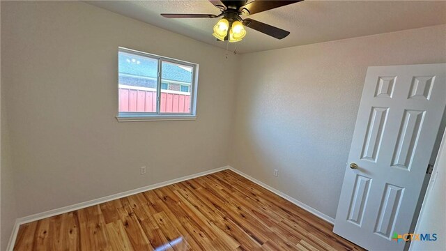 spare room with lofted ceiling, dark wood finished floors, and baseboards