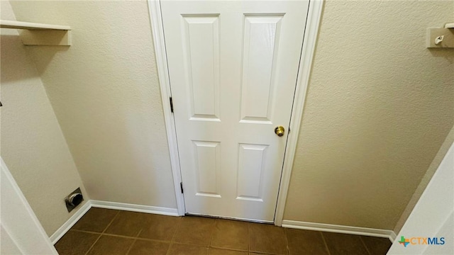 washroom with laundry area, electric dryer hookup, dark tile patterned floors, and baseboards