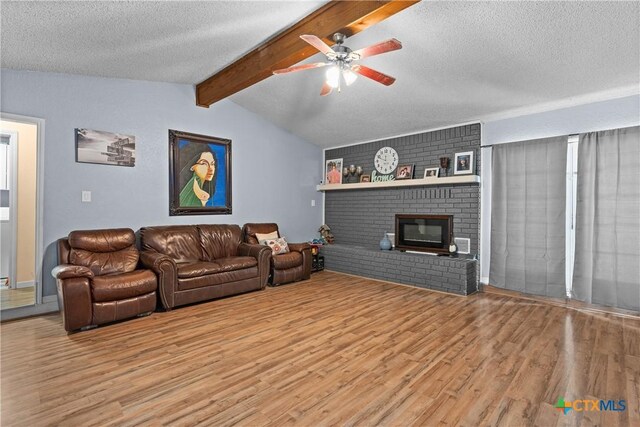 1003 Tyler Dr, Copperas Cove, TX 76522 - living area with wood finished floors, a textured ceiling, a ceiling fan, and a fireplace