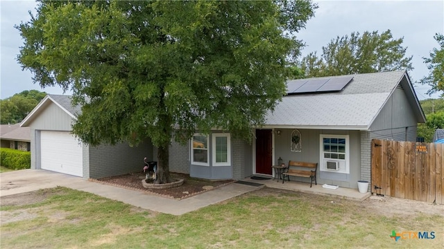1003 Tyler Dr, Copperas Cove, TX 76522 - view of front of house with a garage, roof mounted solar panels, concrete driveway, a shingled roof, and brick siding