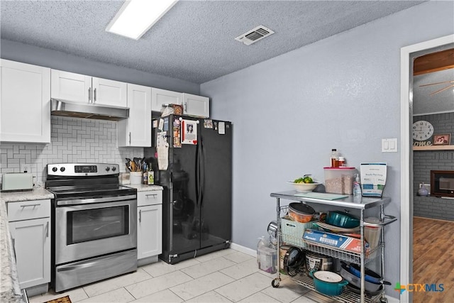 1003 Tyler Dr, Copperas Cove, TX 76522 - kitchen featuring electric range, under cabinet range hood, freestanding refrigerator, white cabinets, and backsplash