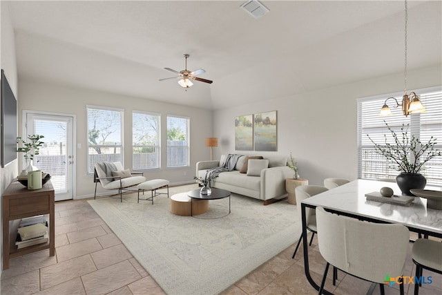 living room with vaulted ceiling and ceiling fan with notable chandelier