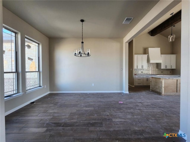 unfurnished dining area featuring vaulted ceiling with beams, dark hardwood / wood-style floors, and plenty of natural light