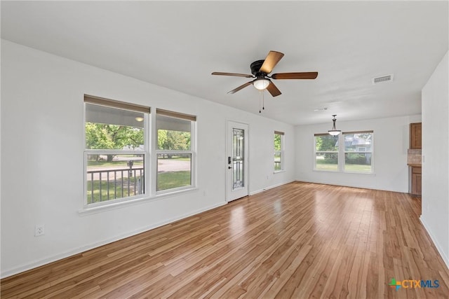 unfurnished living room featuring light wood-type flooring, ceiling fan, and baseboards
