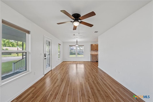 unfurnished dining area with light wood-style flooring, baseboards, and a ceiling fan