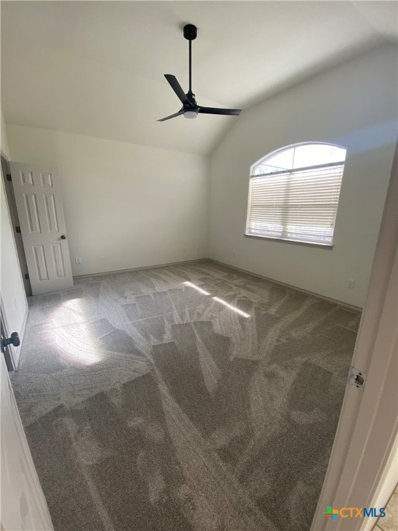 spare room featuring carpet flooring, ceiling fan, and lofted ceiling