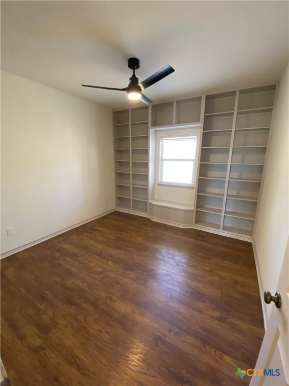 spare room featuring ceiling fan and dark wood-type flooring