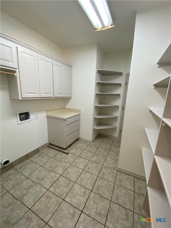 laundry room with washer hookup, cabinets, and light tile patterned floors