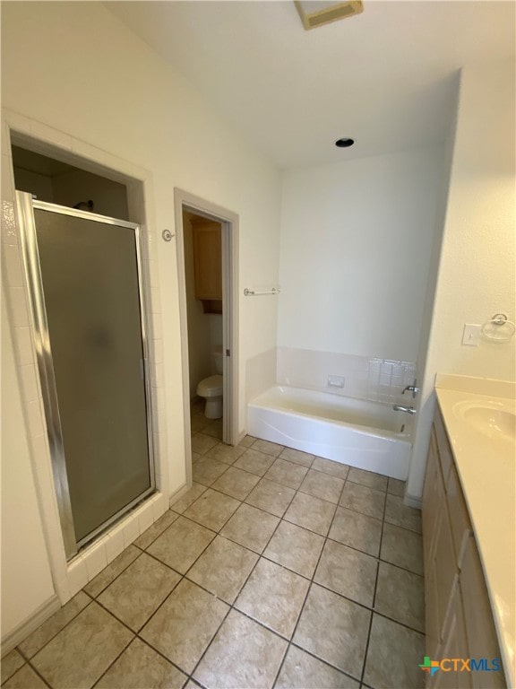 full bathroom featuring toilet, vanity, separate shower and tub, and tile patterned floors