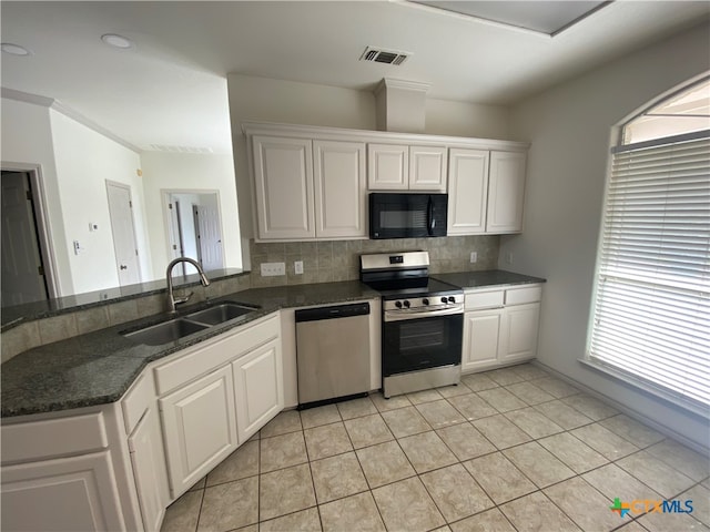 kitchen featuring white cabinets, stainless steel appliances, plenty of natural light, and sink