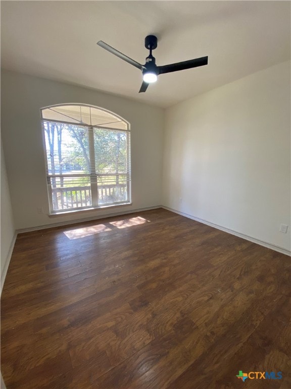 unfurnished room with ceiling fan and dark hardwood / wood-style flooring