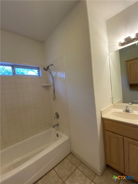 bathroom with tile patterned floors, tiled shower / bath combo, and vanity