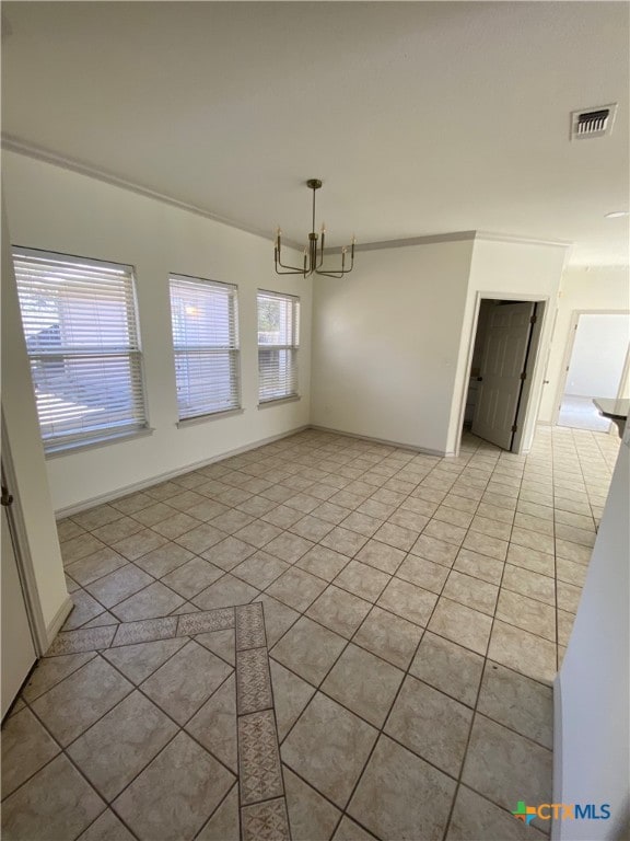 unfurnished dining area featuring crown molding, plenty of natural light, light tile patterned flooring, and a chandelier