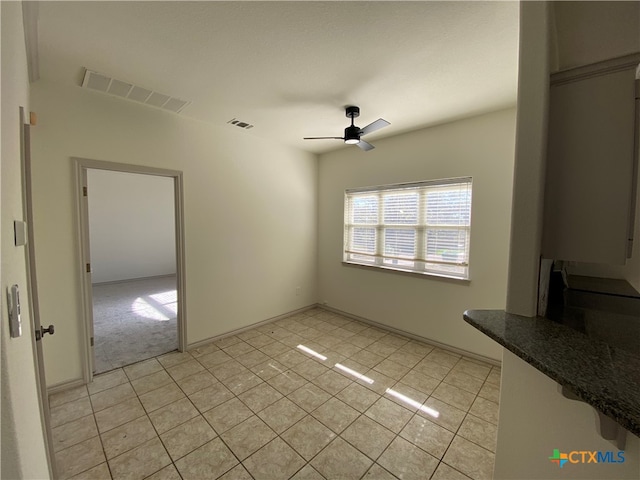 unfurnished dining area featuring ceiling fan and light tile patterned flooring