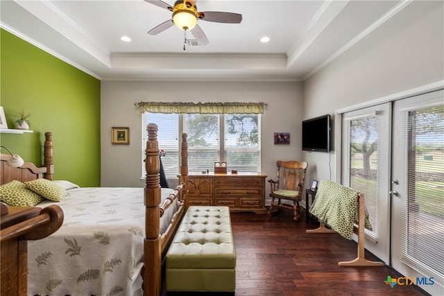bedroom featuring crown molding, a raised ceiling, dark wood-style floors, and multiple windows
