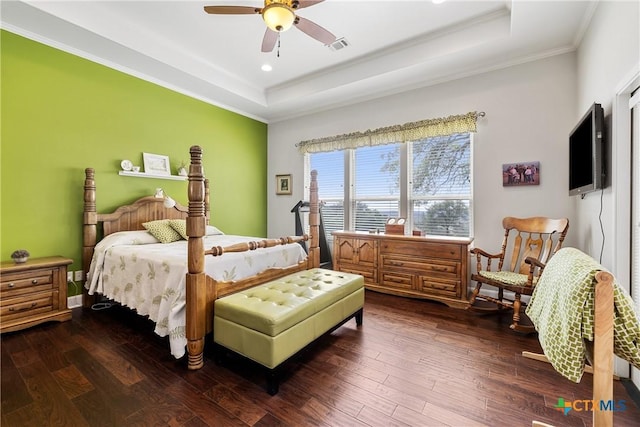 bedroom with recessed lighting, a tray ceiling, dark wood-style floors, and ornamental molding