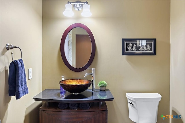 half bathroom with toilet and vanity