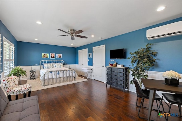 bedroom featuring wainscoting, ceiling fan, recessed lighting, a wall unit AC, and hardwood / wood-style flooring