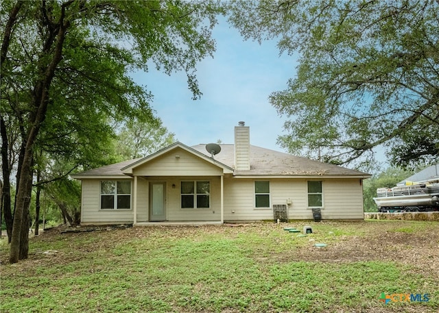 rear view of house featuring a lawn