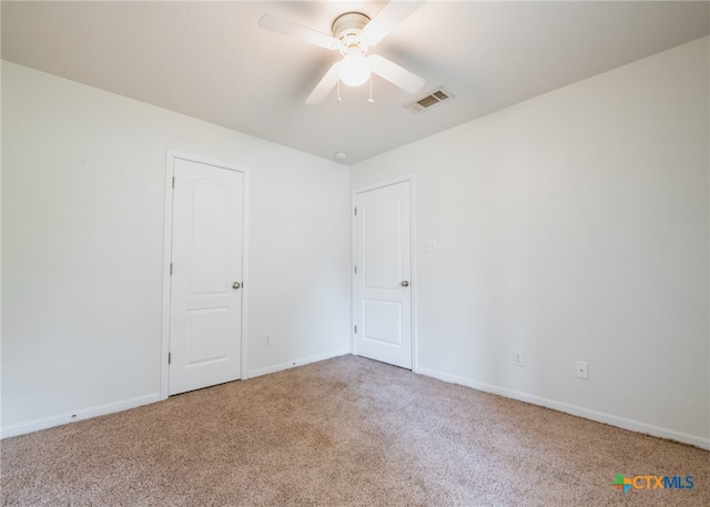 spare room with ceiling fan and carpet