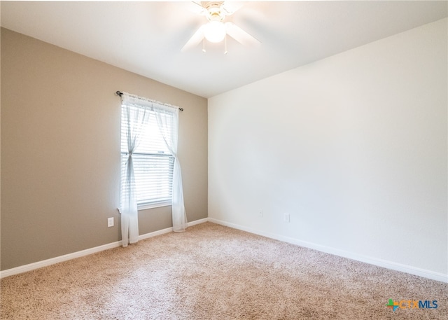 carpeted spare room featuring ceiling fan