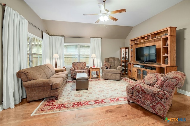 living room featuring ceiling fan, vaulted ceiling, and light wood-type flooring