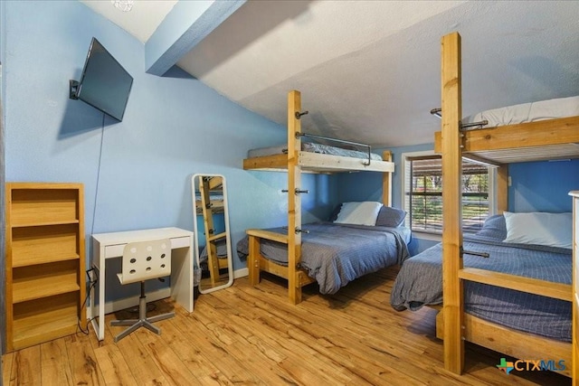 bedroom with vaulted ceiling and light hardwood / wood-style flooring