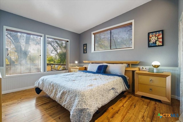 bedroom with hardwood / wood-style flooring and vaulted ceiling