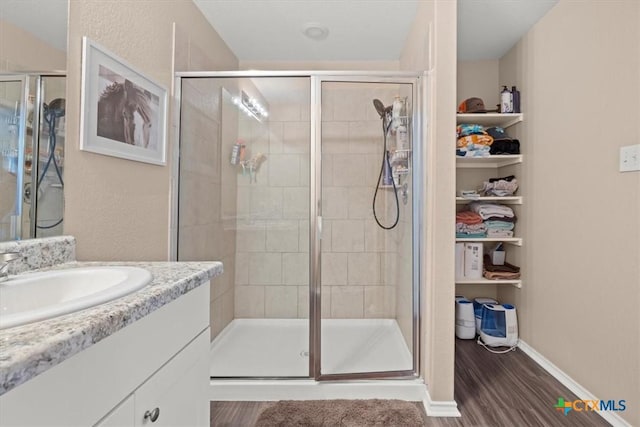 bathroom featuring vanity, hardwood / wood-style floors, and walk in shower