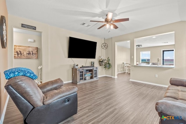 living room with hardwood / wood-style flooring and ceiling fan