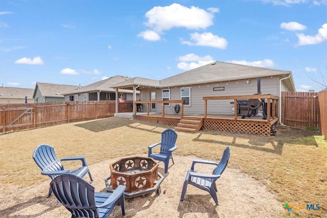 rear view of property featuring a deck and an outdoor fire pit