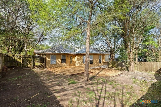 127 Dolly St, San Marcos, TX 78666 - rear view of house with a deck, metal roof, and a fenced backyard