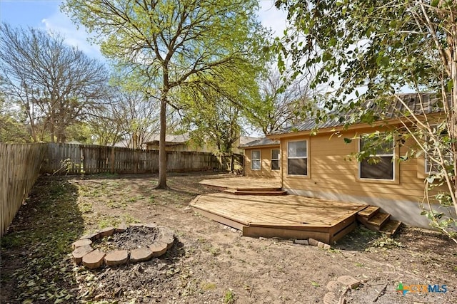 127 Dolly St, San Marcos, TX 78666 - view of yard featuring a fenced backyard, a wooden deck, and a fire pit