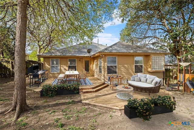 127 Dolly St, San Marcos, TX 78666 - rear view of house with an outdoor living space, outdoor dining area, fence, metal roof, and a wooden deck