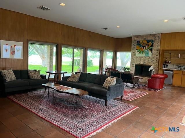 6014 Country Club Dr, Victoria, TX 77904 - living room with recessed lighting, wood walls, a brick fireplace, and visible vents