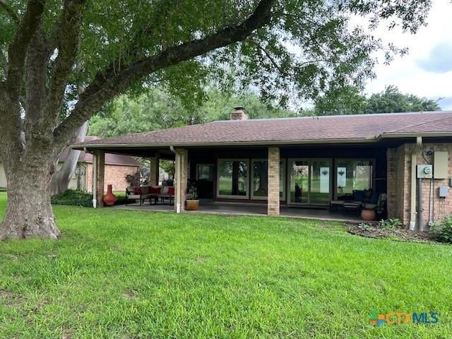 6014 Country Club Dr, Victoria, TX 77904 - rear view of property featuring brick siding, a yard, a chimney, and a patio