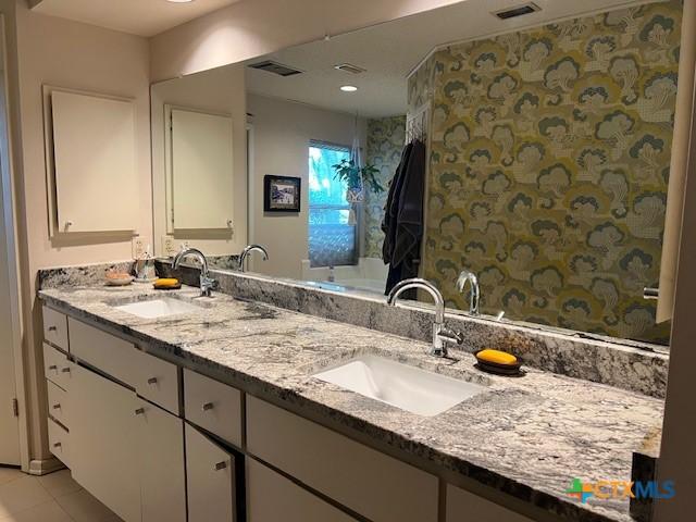 6014 Country Club Dr, Victoria, TX 77904 - bathroom featuring a sink, tile patterned floors, double vanity, and visible vents