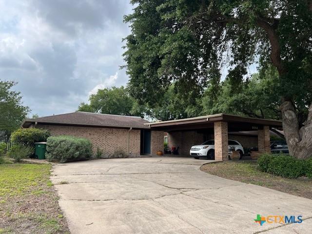 6014 Country Club Dr, Victoria, TX 77904 - single story home with concrete driveway, brick siding, and a carport