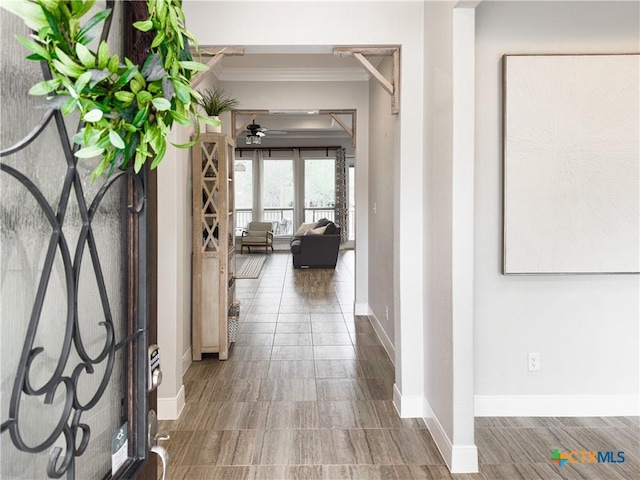 hall with crown molding and baseboards