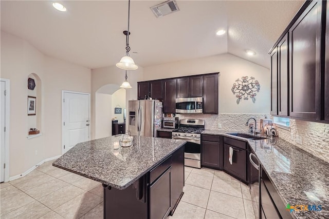 kitchen featuring stainless steel appliances, sink, pendant lighting, a center island, and lofted ceiling