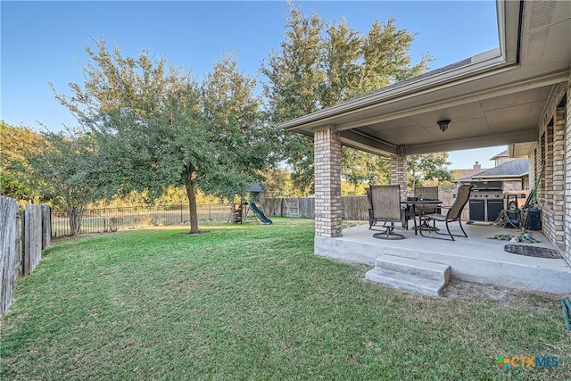 view of yard featuring a playground and a patio area