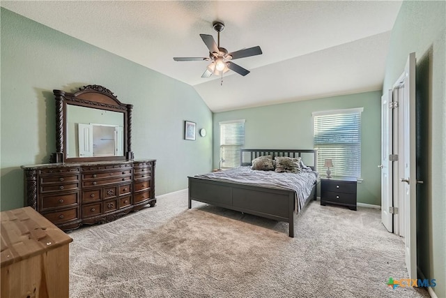 carpeted bedroom featuring a textured ceiling, vaulted ceiling, and ceiling fan