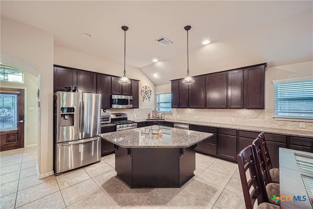 kitchen featuring a healthy amount of sunlight, hanging light fixtures, appliances with stainless steel finishes, and vaulted ceiling