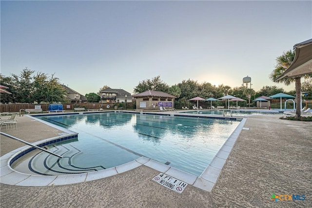 pool at dusk with a patio