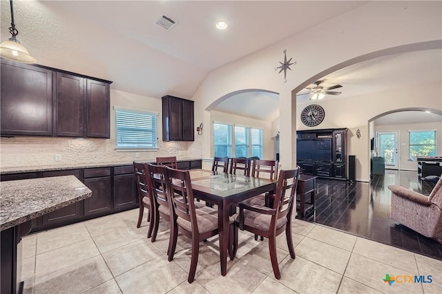 dining area featuring light tile patterned floors, vaulted ceiling, a wealth of natural light, and ceiling fan