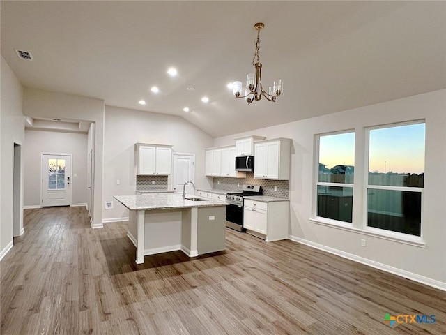 kitchen featuring sink, stainless steel appliances, light hardwood / wood-style floors, vaulted ceiling, and white cabinets